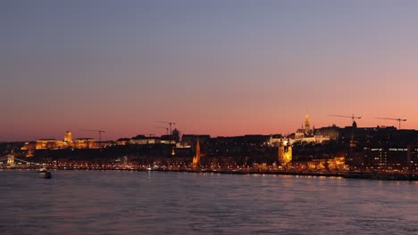 Twilight-timelapse-of-Daube-River,-Buda-Castle-and-illuminated-Budapest-skyline