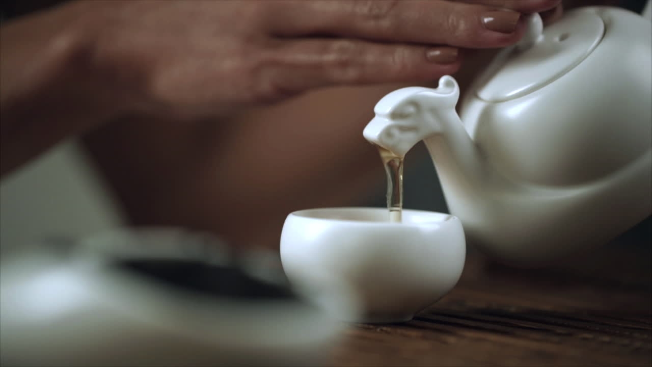 차  ⁇ 비와 컵을  ⁇ 는 것. 오후 차를  ⁇ 는 것. 여자 손이 차  ⁇ 비를 잡는 것