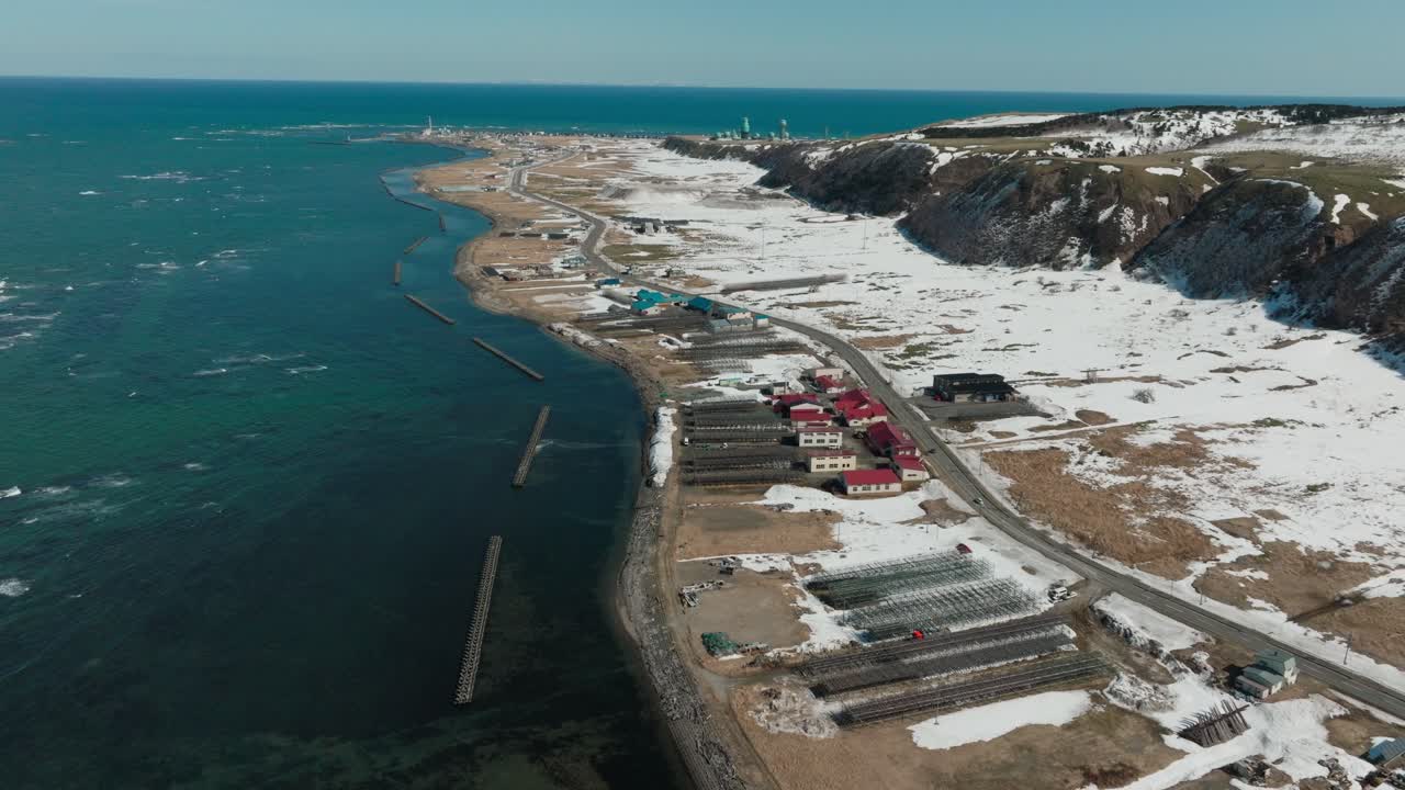Aerial View Of Wakkanai's Snowy Coastline, With Red-roofed Buildings And Icy Shore. Hokkaido, Japan.