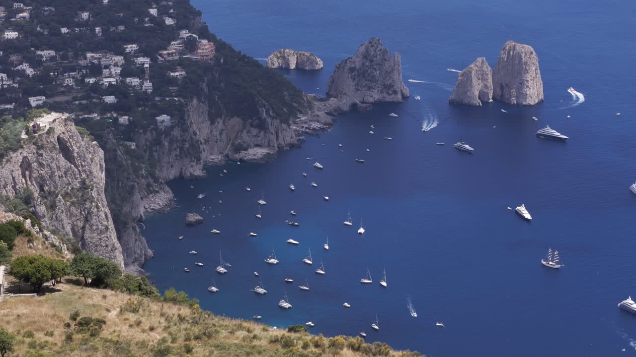 Aerial static drone shot offering a close-up view of the famous Faraglioni rocks, highlighting their natural beauty
