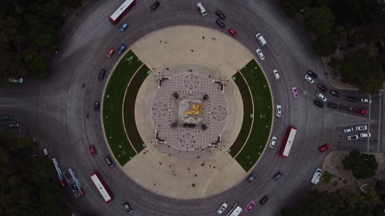 toma cinematográfica de drones del ángel de la independencia mientras los vehículos circulan en la rotonda durante un día nublado