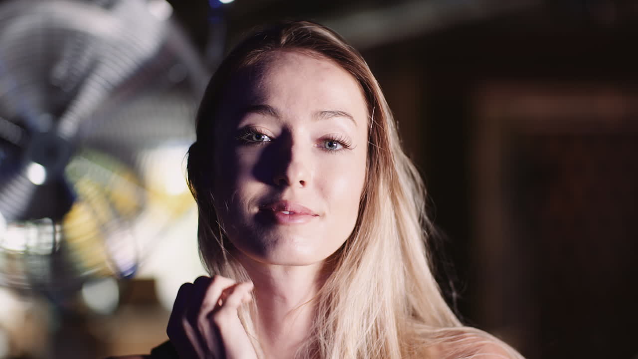 헬스 클럽 4에서 머리를 통해 손을 움직이는 웃는 매력적인 여성 운동 선수의 슬로우 모션