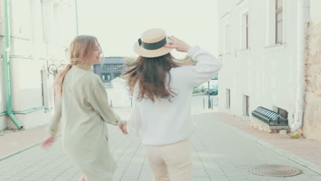 two happy women dancing on a city street