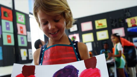 happy girl showing her painting in drawing class