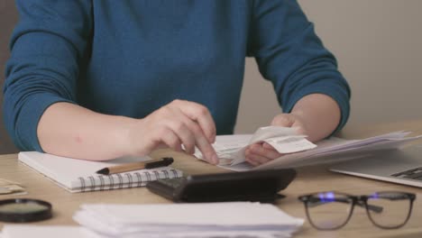 female hands looking through bills payments calculating finances, utility budget