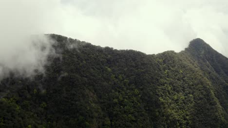 Dulan-mountains-aerial-view-above-lush-peaks---mountain-clouds-pan-right-to,-Taitung-valley-countryside-below