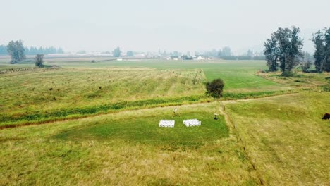 Drone-flys-back-from-ceremony-in-field-with-smoky-sky