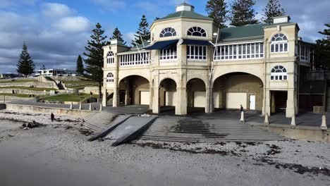 Aerial-pulling-back-from-closeup-of-Surf-Life-Saving-Club-to-wide-Cottesloe-Beach,-Perth