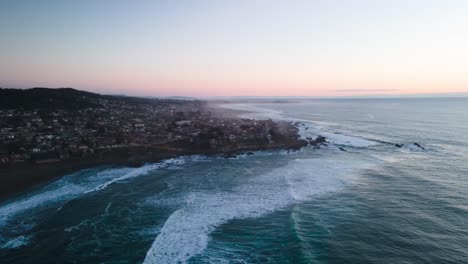 Hyperlapse-Aus-Der-Luft-Eines-Sonnenuntergangs-Am-Strand-Von-Pichilemu-Mit-Wellen,-Die-Gegen-Das-Ufer-Schlagen