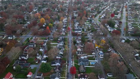 Aerial-shot-of-a-suburban-street-with-autumn-colored-trees