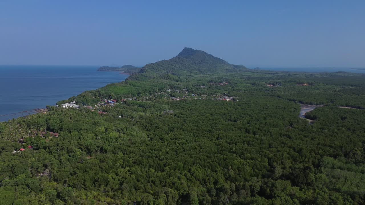 Ripresa cinematografica con drone di una foresta di mangrovie a Koh Jum, nella provincia di Krabi, Thailandia, che mostra canali fluviali tortuosi soggetti a marea, vegetazione densa ed ecosistema costiero con vista mare lontana e sfondo montuoso.