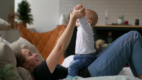 los mejores momentos de la vida, una madre joven feliz y amorosa abraza a un hijo lactante, sobre una manta blanca como la nieve, sobre un fondo blanco. concepto de amor, familia y felicidad concepto: niños, niños, bebé, bebés