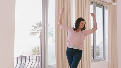 happy-woman-dancing-in-hotel-room-having-fun-enjoying-successful-travel-vacation-healthy-middle-aged-female-celebrating-retirement-at-sunrise