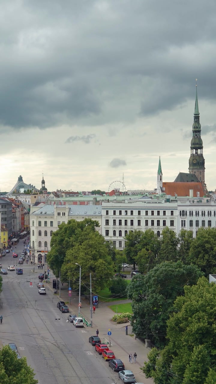 Paesaggio urbano verticale della storica Città Vecchia di Riga con tram, guglie storiche e cielo estivo coperto. Splendido skyline cittadino.