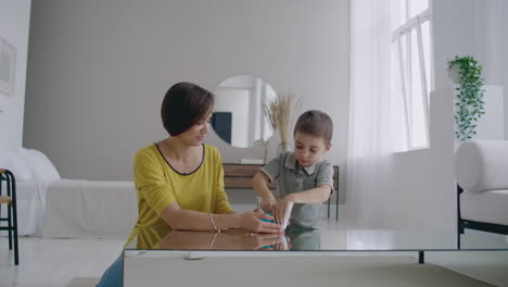 happy and laughing mom and son play together with a lizun a liquid stretchable toy.