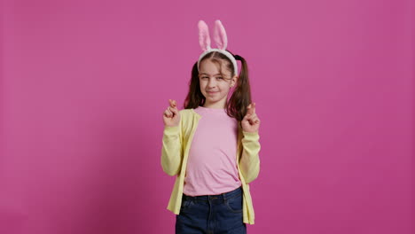 Lovely-sweet-girl-posing-in-studio-with-fingers-crossed