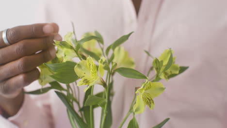 close up of guy touching bouquet of flowers