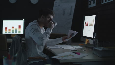 serious businessman working on computer in night office.