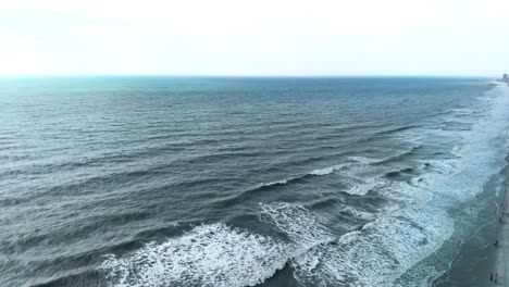 Steady-areal-video-shoot-over-coastline-and-waves-at-the-sea,-peaceful-and-tranquil-atmosphere