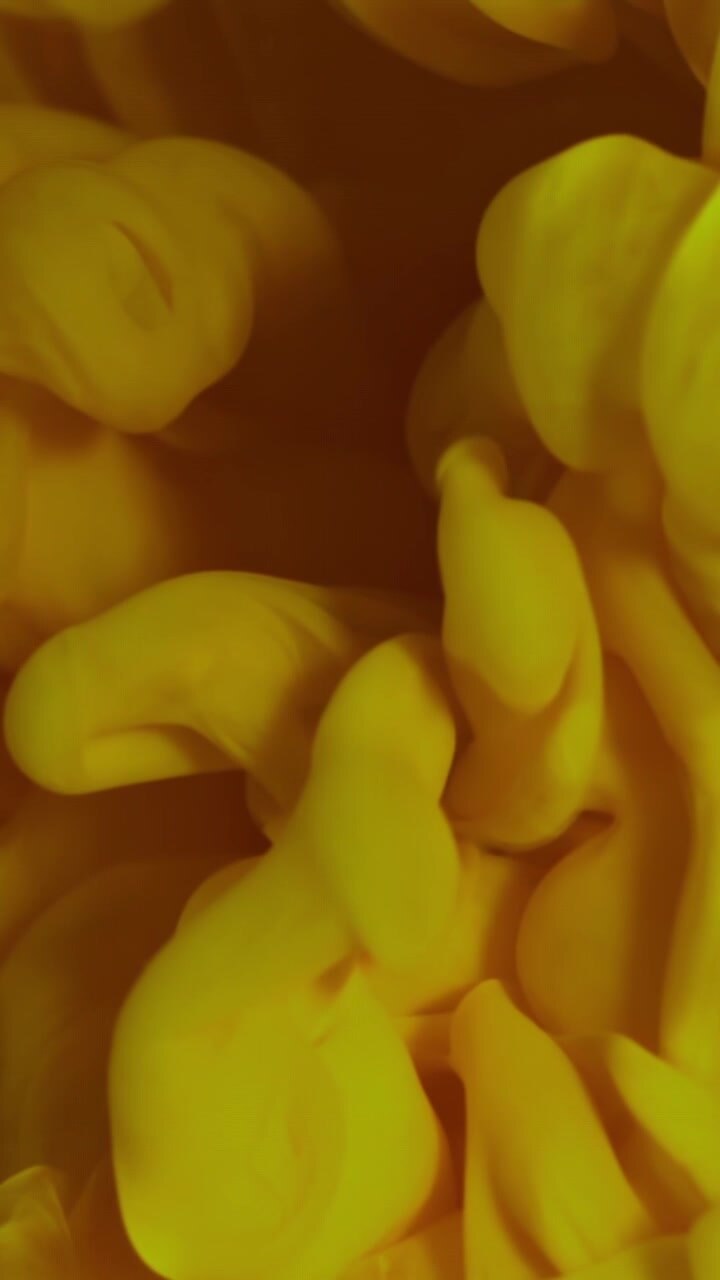 Abstract Yellow Ink Swirling in Slow Motion