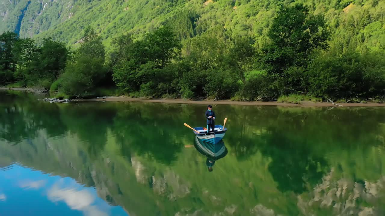 женщина на лодке ловит рыбу на вращении в норвегии.