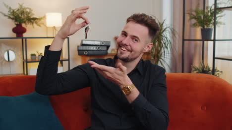 guy real estate agent showing the keys of new home house apartment, buying or renting property