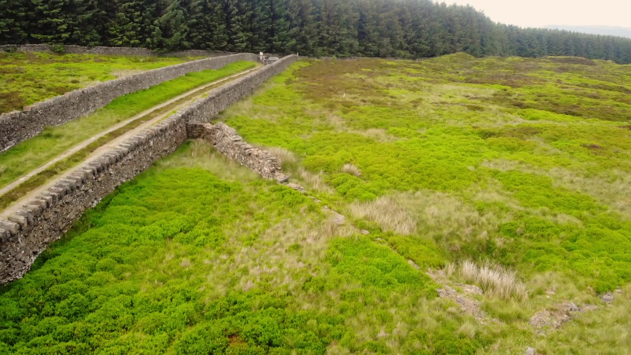 Strada solitaria attraverso le brughiere del Peak District nello Yorkshire, ripresa aerea con zoom del drone e messa a fuoco selettiva.