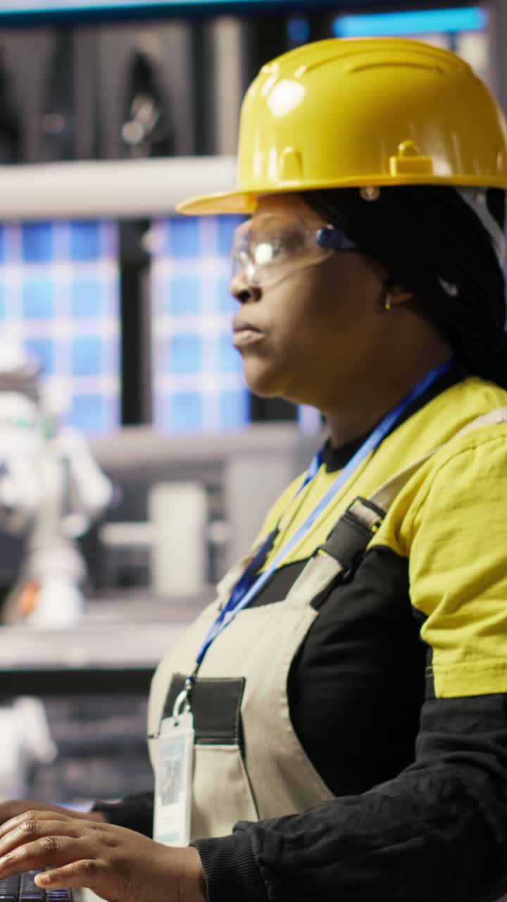 Vertical video Portrait of cheerful factory engineer typing on PC, monitoring production lines