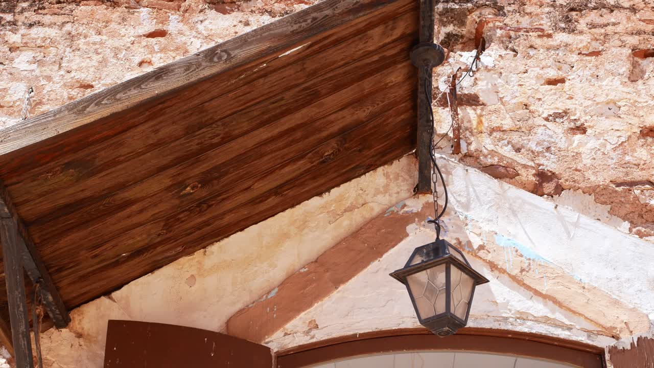 linterna bajo un techo de madera meciéndose en el viento