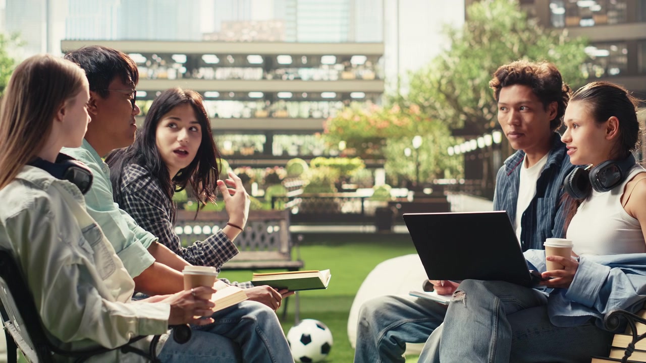 Classmates gesture during group study discussion outdoors on campus