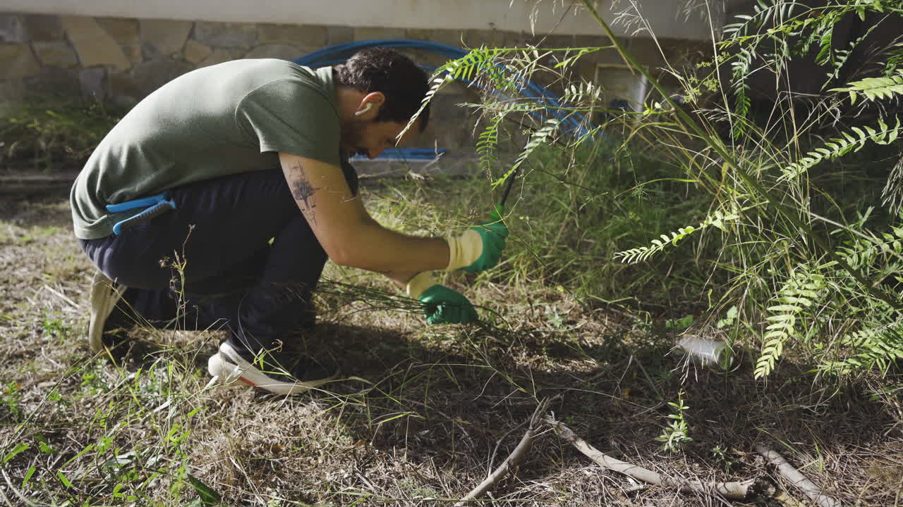 macho joven deshierbe en el jardín y prepara el suelo para la próxima siembra de nuevas plantas