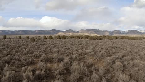 aerial forward dolly shot of desert valley with distant mountains in utah