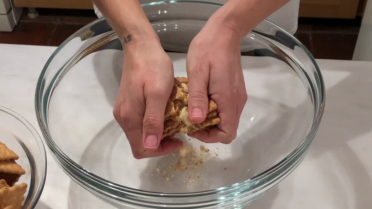 mujer preparando pastel de galleta en un cuenco de vidrio