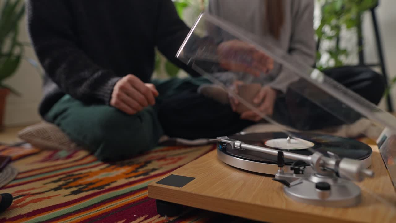 Person listening to music on a vinyl record player