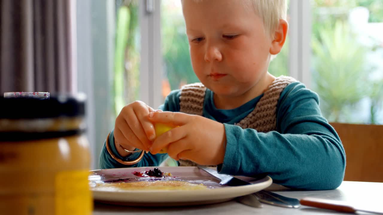 Ragazzo che spreme limone sul pancake a casa 4k