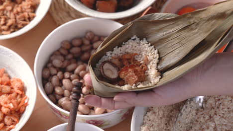 Making zongzi food - preparing and wrapping Chinese rice dumpling.