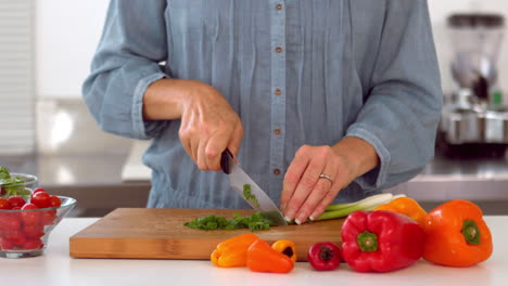 woman slicing spring onion with knife