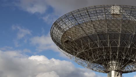 large satellite dish, blue sky and fluffy clouds