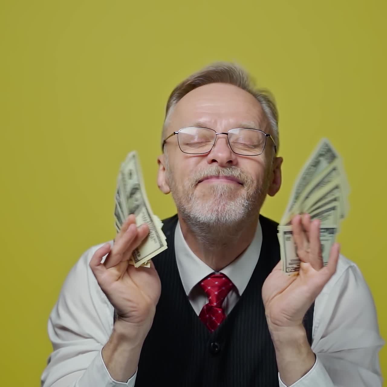 Happy senior man enjoys money. Portrait of an old businessman with many dollar banknotes in his hands. Great business deal.
