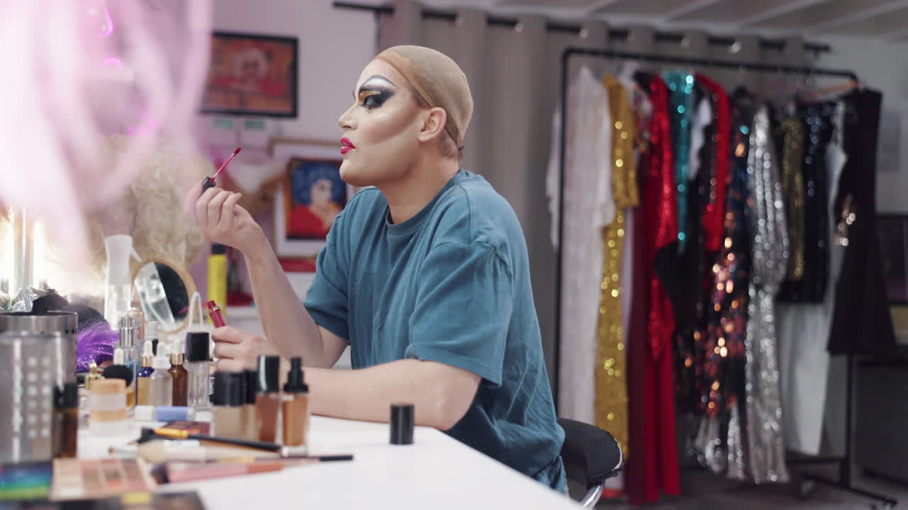 A drag queen applies makeup backstage
