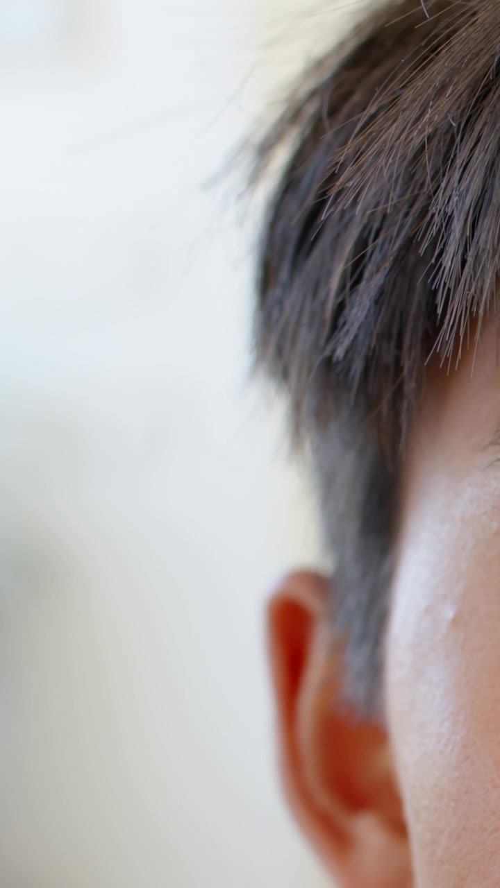 Video verticale: Registrazione della testa di un uomo che respira, con capelli, orecchio e guancia visibili all'interno, spazio per il testo.