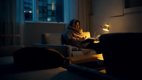 woman reading a book in a cozy evening home setting