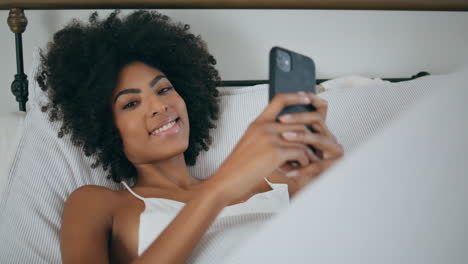 Mujer-Sensual-Descansando-En-La-Cama-Del-Teléfono-Celular.-Retrato,-Africano,-Rizado,-Dama,-Mirar,-Cámara