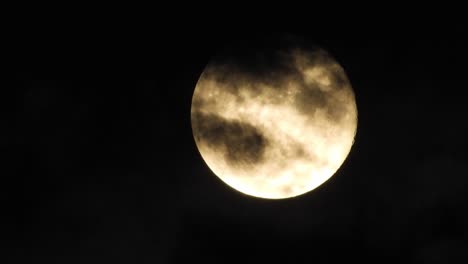 luna por la noche con nubes en tiempo real. 4k video luna en el cielo negro. nubes pasando por la luna por la noite. cielo nocturno con tiempo nublado