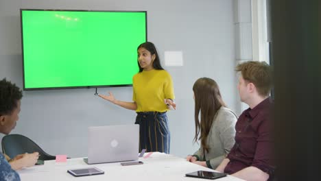mujer dando presentación colegas de negocios usando pantalla verde