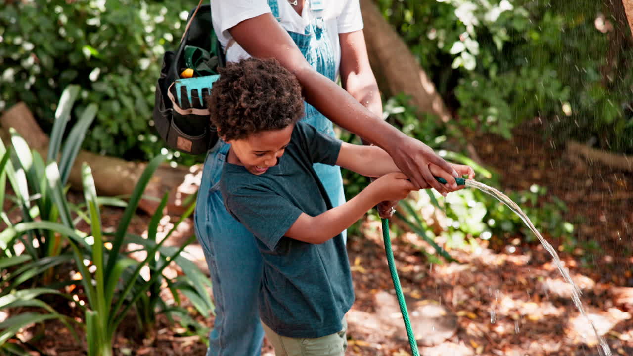 madre y hijo disfrutando de una divertida actividad de riego del jardín