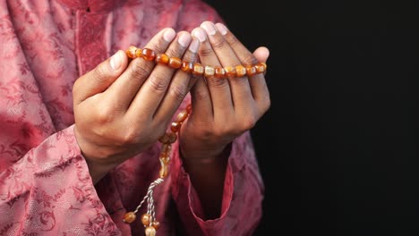 man praying with prayer beads