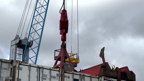 Feste-Aufnahme-Eines-Krans,-Der-Einen-Großen-Container-Im-Seehafen-Hochhält