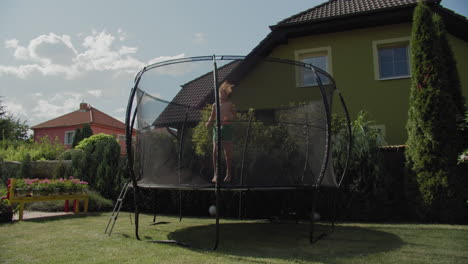 niño de doce años en el trampolín del patio trasero