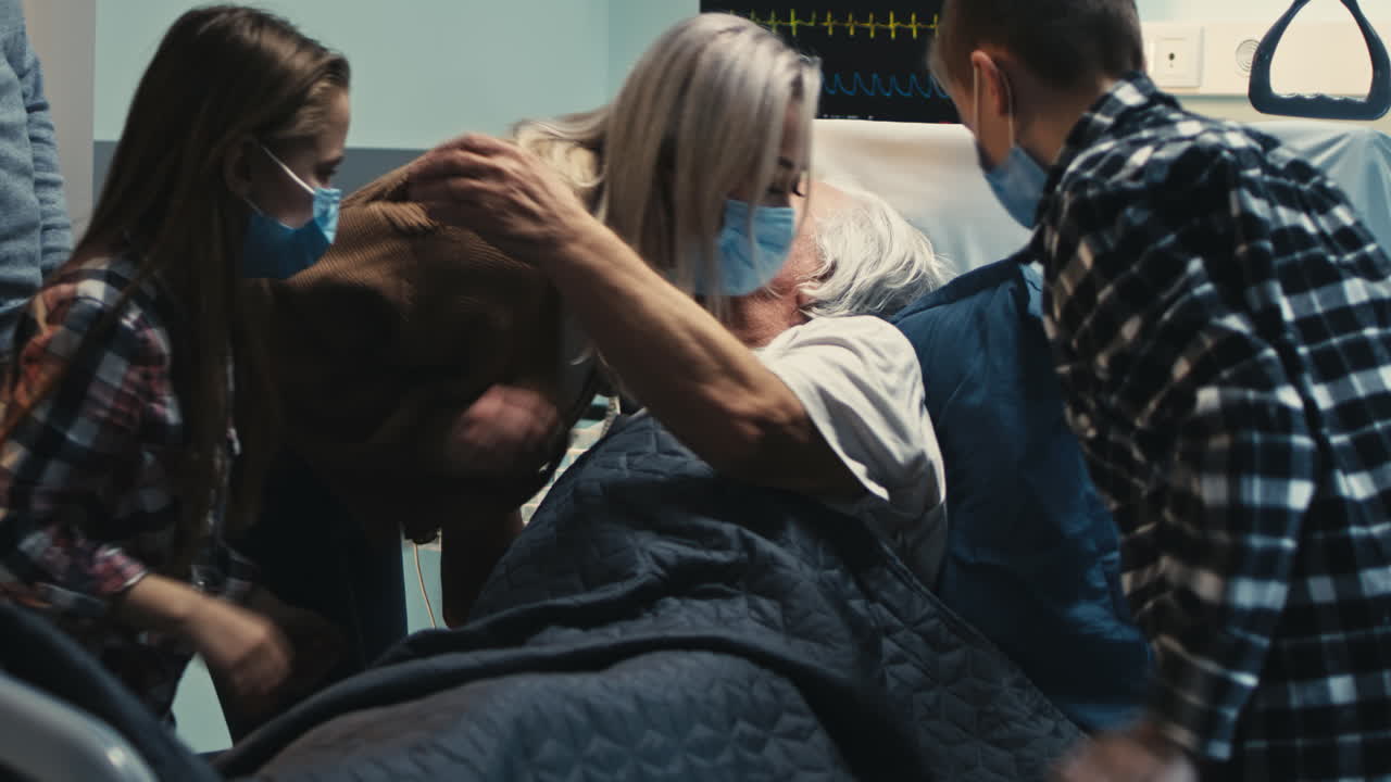 Family comforts an elderly patient in a hospital room